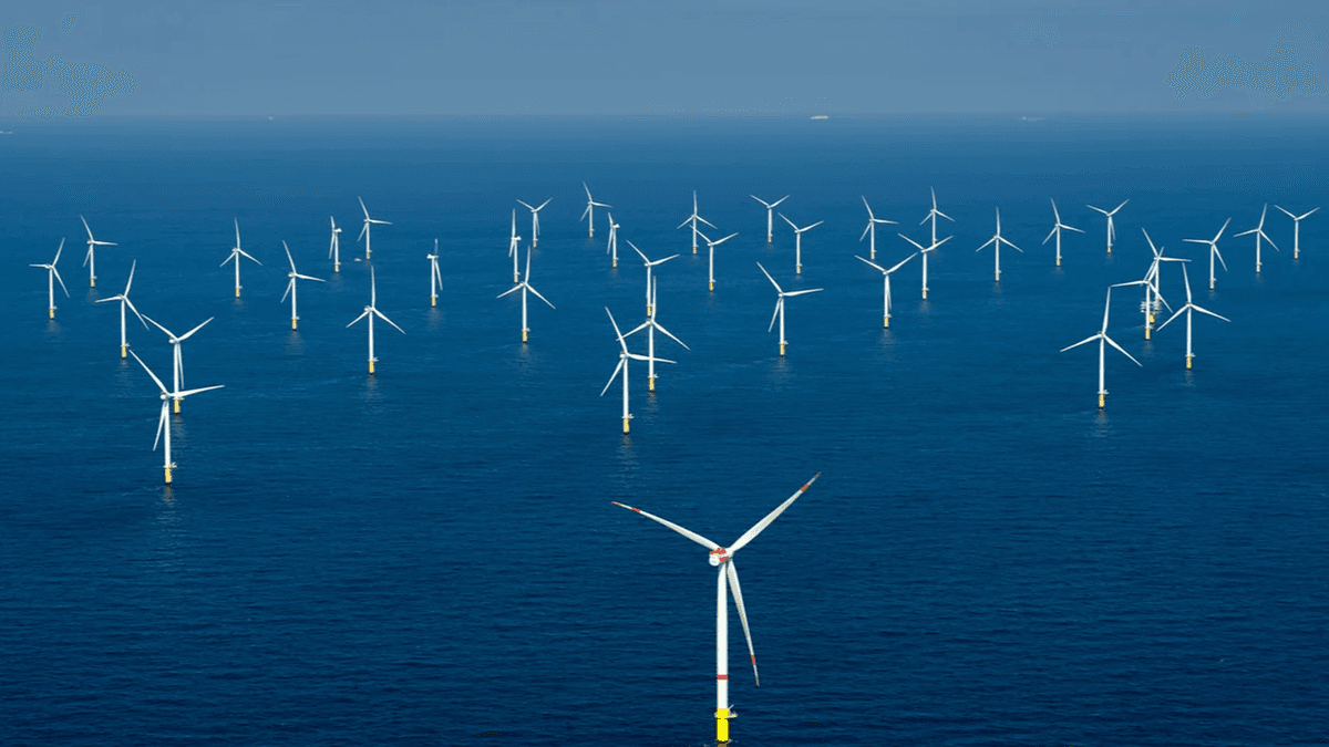 Offshore wind turbines rising out of the ocean, capturing renewable energy for coastal cities.